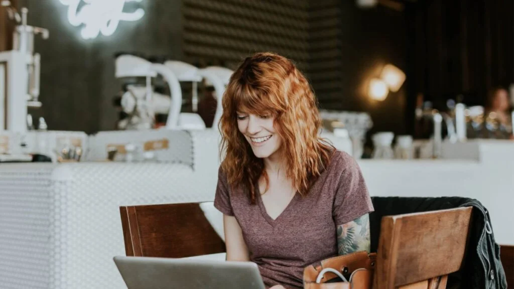 On y voit une entrepreneuse qui travaille avec joie dans un café. grâce aux nombreux conseils de Studio Cap Letter, elle reprends confiance en elle et se booster pour la suite de son aventure entrepreneuriale